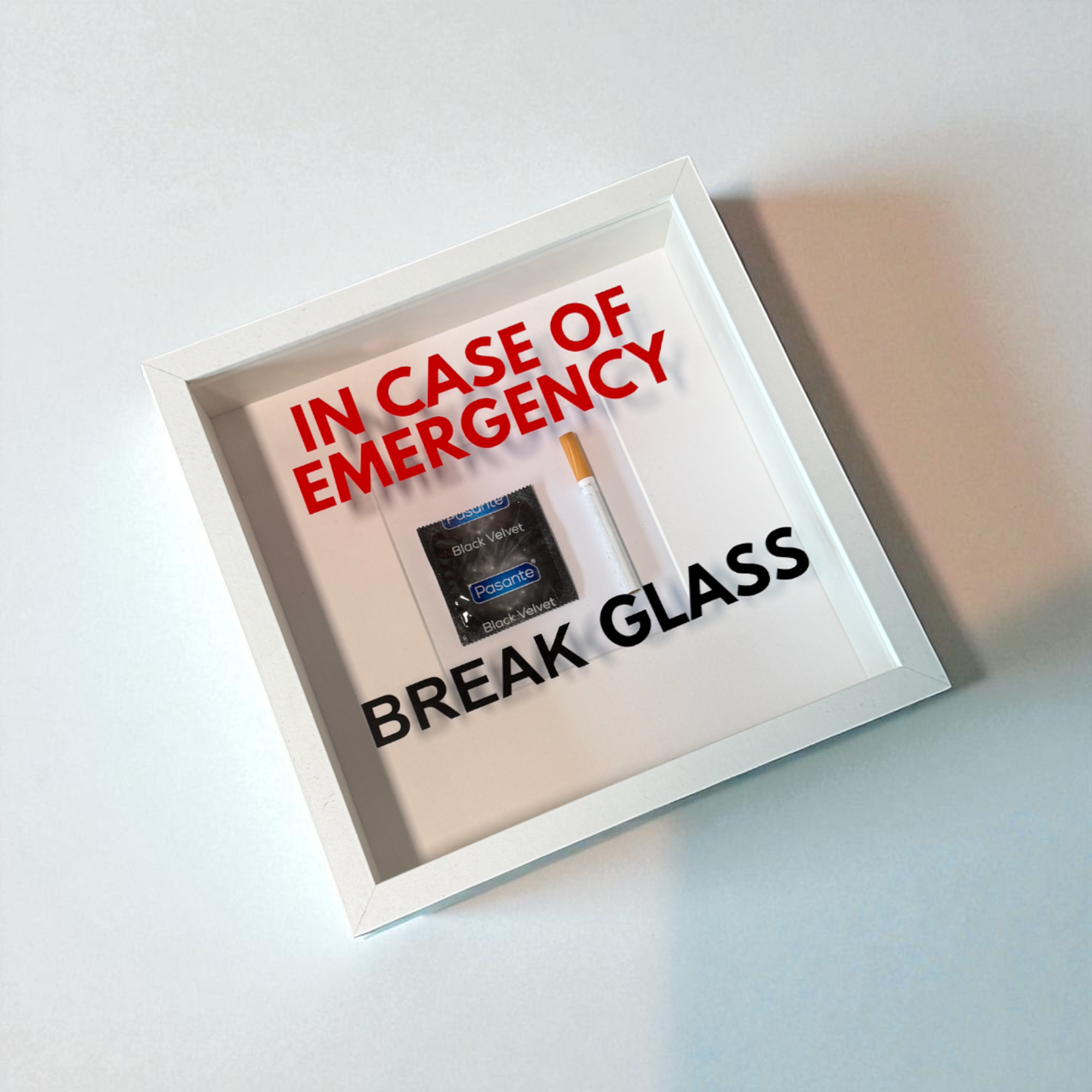 "In Case of Emergency Break Glass" – Wandbild mit Kondom/Zigarette weißer Rahmen