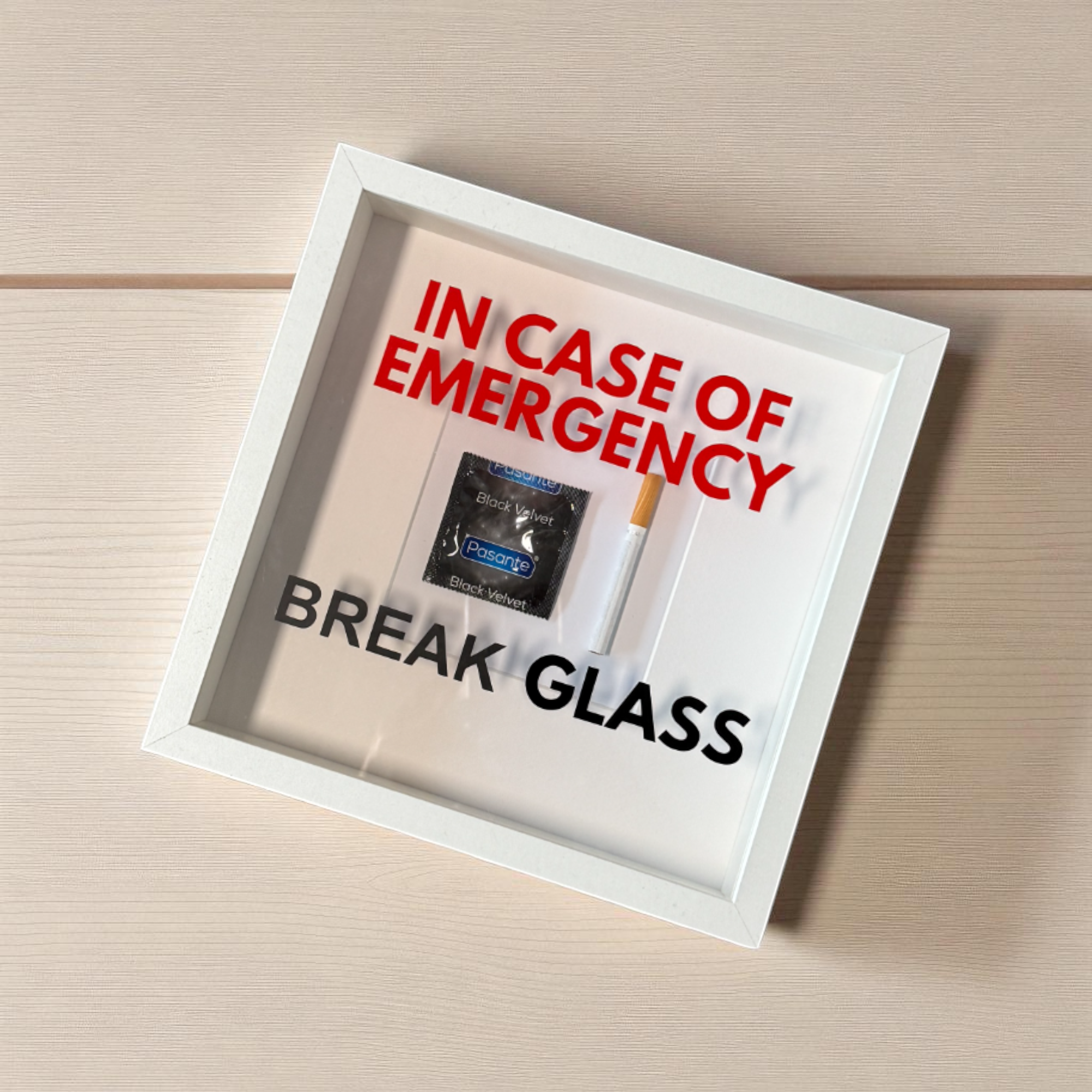 "In Case of Emergency Break Glass" – Wandbild mit Kondom/Zigarette weißer Rahmen