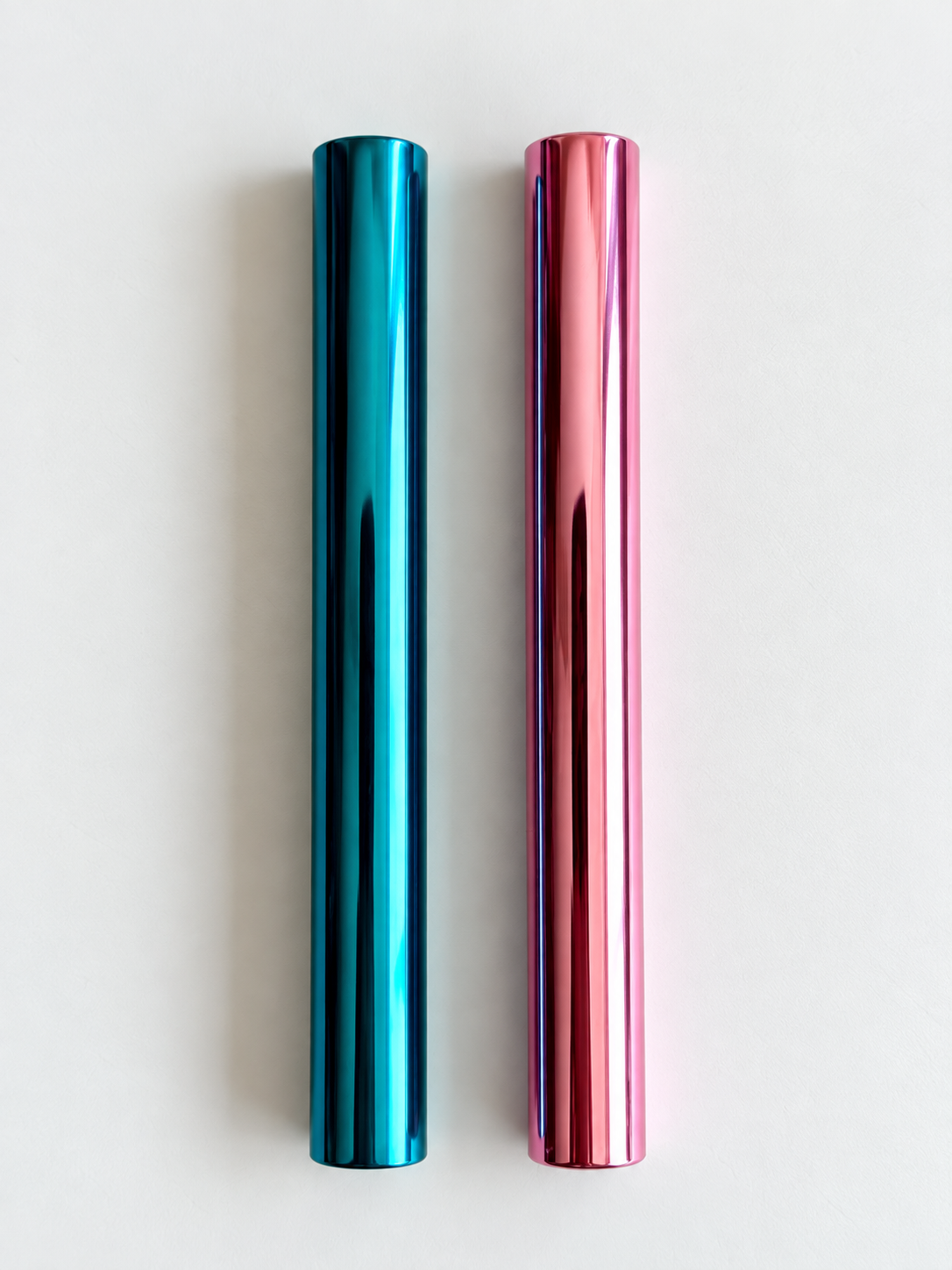 Pinkes und blaues Aluminiumröhrchen mit glänzender Oberfläche, senkrecht nebeneinander auf hellem Grund.